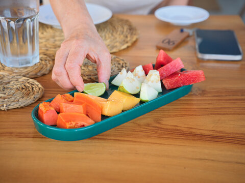 Fresh Fruit Platter Enjoyed at a Table With Water and Phone Nearby