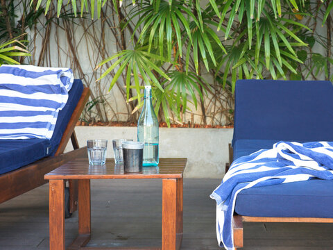 Pool Seating Area With Blue Chairs and a Table Near Green Plants