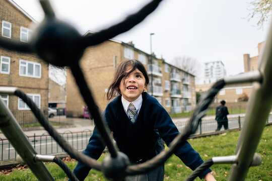 Happy student climbing playground structure after school