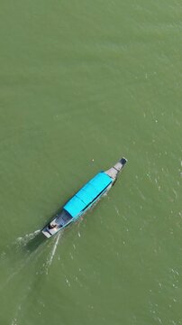 Vertical screen River Craft Executing Sharp Turn. Vessel Navigating Swiftly With Spray And Ripples Along Riverbanks. Aerial View Of Boat Executing Swift Turns On River With Spray Patterns