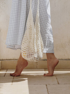 Woman's legs and crocket bag.