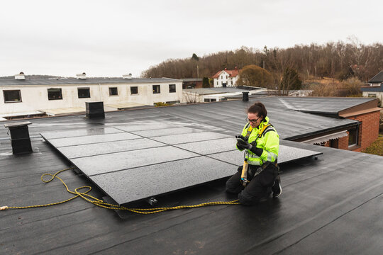 Technician Checking Solar Panels on Flat Roof