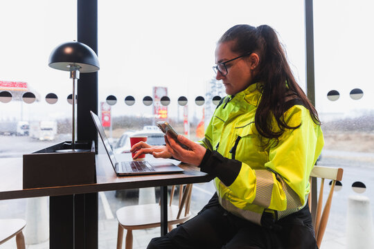 Female Technician Using Phone and Laptop During Break