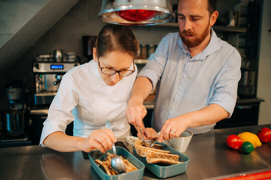 Two chefs working on bone marrow dish in restaurant