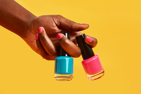 Hand holding colorful nail polish bottles