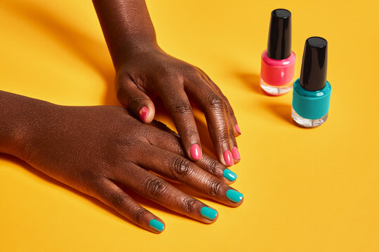 Hands with colorful nail polish displaying beauty manicure