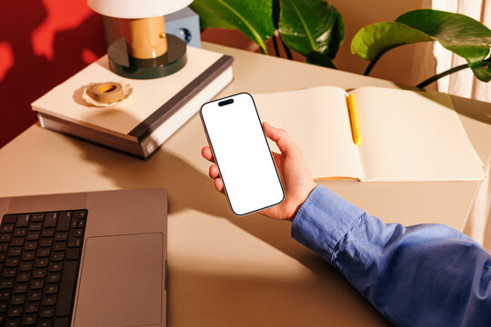Phone mockup with white screen at work desk