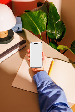 Smartphone mockup with white screen in office workspace