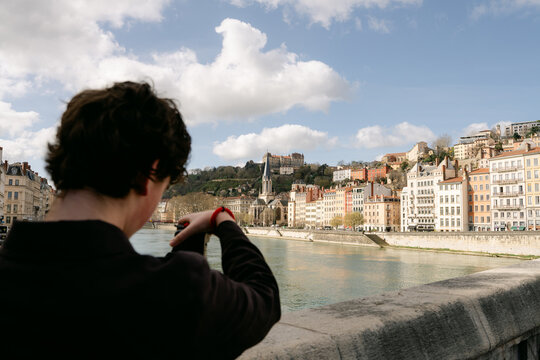 Young man taking photos of Quai Furchiron in Lyon France