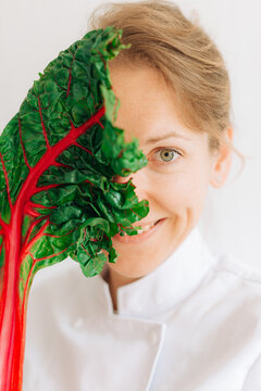 Creative chef portrait with chard leaf covering half face