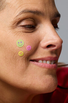 Woman With Smiley Face Stickers on Her Cheek in a Studio