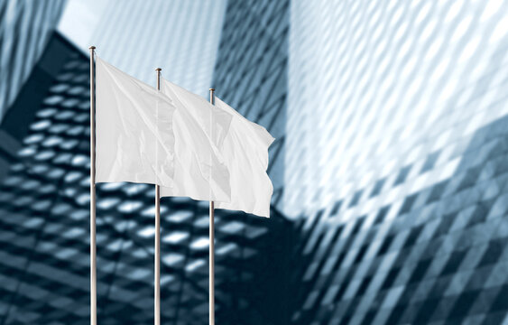 Three white flags with copy space against modern office building