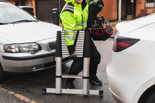 Technician Removing Service Ladder from Vehicle