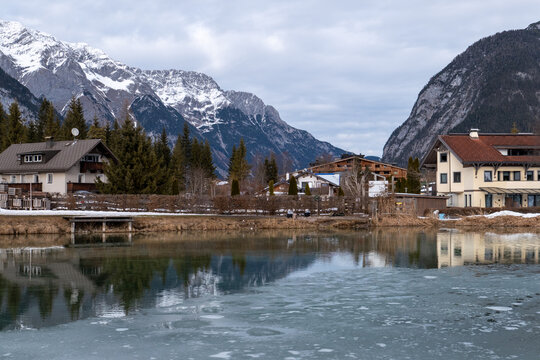 Quiet Alpine Village Reflected In Frozen Mountain Lake