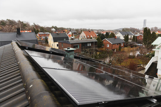 Elevated perspective of solar panel arrays across a suburban area