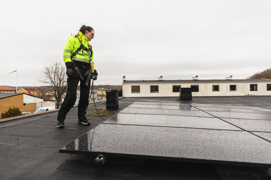 Professional Technician Inspecting Commercial Solar Panel Array