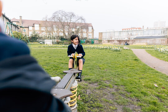 Child playing on seesaw after school in park