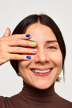 Woman smiling showing colorful manicure nails