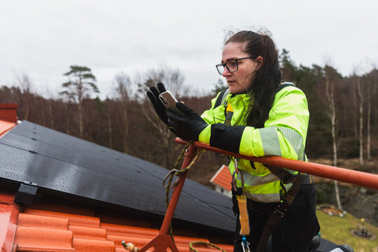 Technician Using Smartphone During Solar Inspection