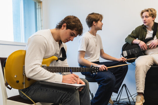 Student band members writing music during rehearsal