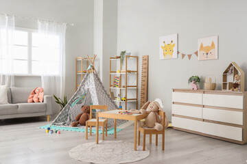 Interior of light playroom with play tent, table and shelf units in kindergarten © Pixel-Shot