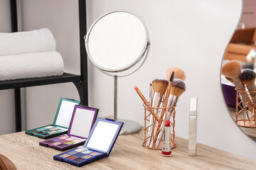 Cosmetic products with mirror on makeup artist's table in office