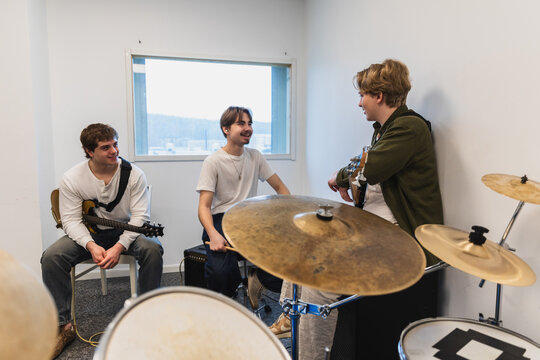 Young male student band rehearsing in a bright music studio
