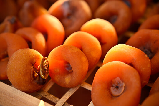 Closeup of dried persimmons drying in the natural sunlight