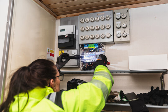 Technician Inspecting Electrical Fuse Box