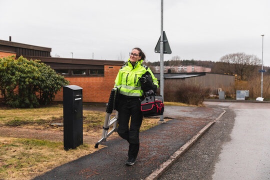 Professional Female Electrician Arriving at Residential Job Site