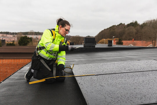 Specialist Measuring Solar Panel Placement on Flat Roof