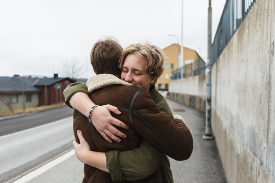 Friends hugging in the middle of a street