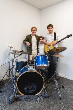 Portrait of a three-member student band with drums
