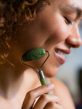 Woman Uses Jade Roller on Her Face for Skincare Routine
