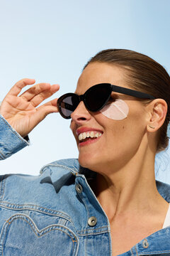 Woman Wears Sunglasses and Skincare Patches Outdoors During the Day