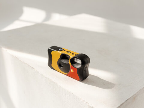 Colorful Disposable Film Camera On White Pedestal 