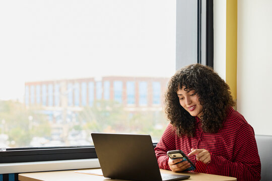 Businesswoman at Desk Working With Laptop and Phone