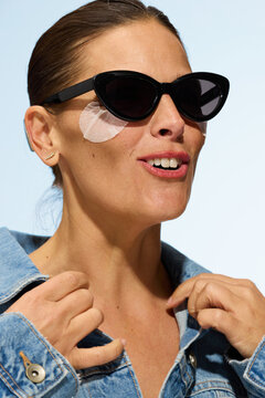 Woman Wearing Sunglasses With Skincare Patches in Bright Setting