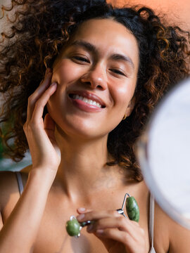 Woman examining skin after massage and skin care 