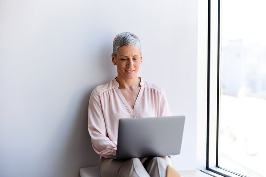 Businesswoman works on a laptop while sitting comfortably