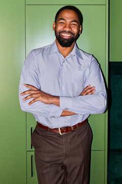 Portrait of a happy businessman against green background