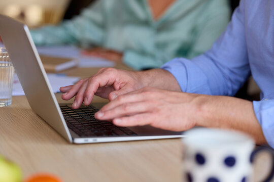 Anonymous man uses a laptop on a meeting