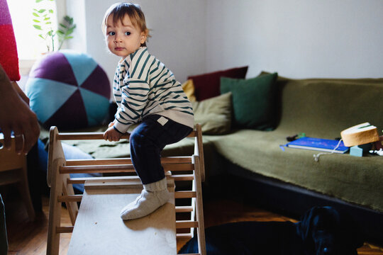 Toddler Playing Indoors on Wooden Climbing Frame