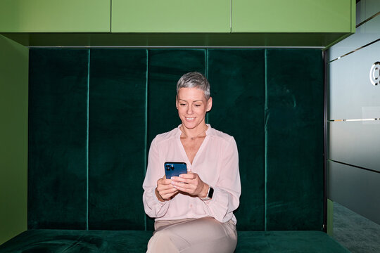 Portrait of a businesswoman sends texts via mobile phone