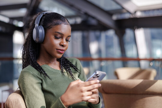Woman relaxing with an audiobook while using phone