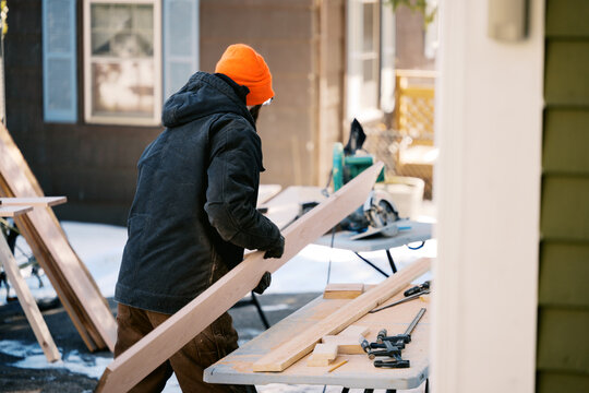 man measuring and sawing oak wood boards for diy project