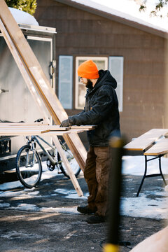 man measuring and sawing oak wood boards for diy project