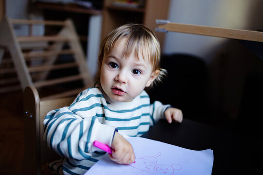 Toddler Drawing With Pink Marker at Table