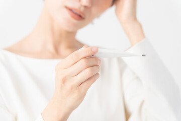 Fototapeta premium 体温計を使う女性 健康イメージ
