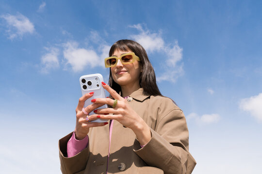Bright spring day with a young woman using her phone outdoors